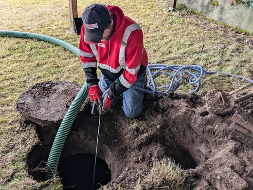 Septic Technician Pumping and Cleaning a Septic Tank in Lakebay